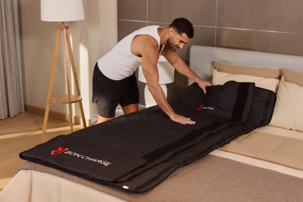 Man Setting Up Infrared Sauna Blanket on Bed